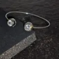 Primer plano detallado de una pulsera plateada con circonitas cúbicas redondas y brillantes. - Estilo Diamante Redondo / Plateado
