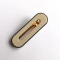 Close-up detail of minimal oval acrylic hair clip with gold metal spring mechanism and black rim. - S316 / Rounded Rectangle White