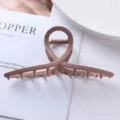 Close-up detail of matte pink geometric hair claw clip, showing cross circular design texture. - Crossed Rings Style (98#)