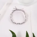 Detail view of grey braided hair rope adorned with white small pearls and a cute bow. - Gray