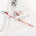 Detail view of a colorful marbled acetate hair stick with traditional hollow carved head. - Multicolor