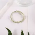 Close-up detail of green braided hair rope with white pearl accents, elegant accessory. - Green