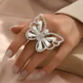 Primo piano dettagliato di un grande anello con farfalla in strass indossato, cristalli scintillanti. - Stile Farfalla (MS260)