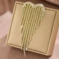 Primo piano dettagliato della spilla con nappe a cuore in strass finitura dorata. - Stile Nappina in Strass Cuore Dorato (MS355-2)