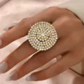 Primo piano di uno splendido anello geometrico in strass scintillante indossato sulla mano. - Stile Grande Disco Rotondo (MS257-2) / Oro