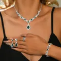 Close-up detail of luxury green crystal necklace, earrings, ring, and bracelet jewelry set. - Four-Piece Set / Green