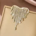 Dettaglio della spilla a cuore con nappe in strass che mette in risalto cristalli brillanti dorati. - Stile Nappina in Strass Cuore Dorato (MS362-2)