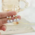 Pendientes de lazo de cristal delicados con dijes de estrás para un estilo dulce y chic. - Pendientes de botón de carillón de viento