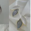 Chic leaf stud earrings featuring a stylish dual-tone white and grey design with gold rim. - Leaf
