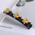 Detailopname van zwarte dubbellaagse haarspeld met gele vlinders en strass-steentjes voor haar. - #10 Dubbellagige strass eendenbekclips voor vlechtwerk