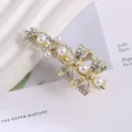 Detailed view of gold-tone metal rhinestone and pearl bow hair clip, elegant hair accessory. - Bowknot Rhinestone Duckbill Clip / Gold