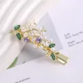 Gold metal hair clip featuring a white enamel butterfly, green leaves, pearls, and purple rhinestones. - Butterfly Rhinestone Duckbill Clip / Gold