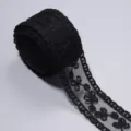 Nahaufnahme von schwarzem Spitzenband, das die feine florale Stickerei zeigt. - 5 Yards Packung / Schwarz