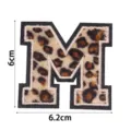Écusson brodé lettre M imprimé léopard, vue de détail pour loisirs créatifs et vêtements. - Lettre M
