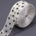 Sheer organza ribbon roll with black heart print, perfect for DIY bows, gift wrapping and crafts. - Beige