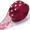 Primo piano dettagliato del nastro in organza trasparente bordeaux con motivo a cuori. - Borgogna