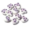 Gros plan détaillé de perles en céramique en forme de cœur avec motif floral pour bijoux. - Forme de Cœur Petite Fleur Violette