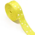 Detail view of bright yellow grosgrain ribbon featuring a cute white star print design. - Ten Yards Pack / Yellow