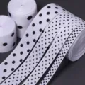 Detailed view of white grosgrain ribbons with black polka dots for DIY bows and gift wrapping. - Ribbon Width 1.5cm (10 Yards/Roll) / White