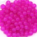 Gros plan de perles de verre roses, parfaites pour la fabrication de bijoux et bracelets DIY. - Rose rouge