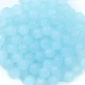 Gros plan de perles rondes en verre bleu clair pour fabrication de bijoux et accessoires. - Bleu clair