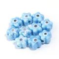 Close-up detail of light blue ceramic evil eye flower beads, perfect for DIY jewelry crafting. - 10 Pieces/Pack / Blue