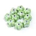 Ceramic flower beads with evil eye pattern, perfect for handmade DIY jewelry making. - 10 Pieces/Pack / Green