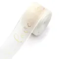 Detailansicht von weißem Organzaband mit goldenem Love-Druck für Geschenke und Dekoration. - Liebe