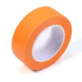 Gros plan détaillé du rouleau de ruban de masquage orange montrant la texture du papier. - Largeur 2cm (13m/Rouleau 1Rouleau/Paquet) / Orange