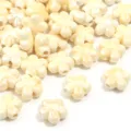 Primo piano di perline di fiori in ceramica lucida per la creazione di gioielli fai-da-te. - Beige Floreale