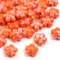 Primo piano dettagliato di perline di ceramica arancione lucido a forma di fiore a cinque petali. - Piccolo fiore arancione