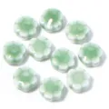 Dettaglio di perline di fiori di margherita in ceramica, ideale per gioielli DIY e bracciali. - Margherita Verde Pisello