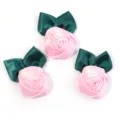 Detailopname van handgemaakte satijnen lint rozenknoppen met groene bladeren voor knutselen. - 5-6cm / Roze