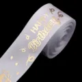 Close-up of white polyester ribbon with gold foil Happy Birthday print for gift box dec. - White