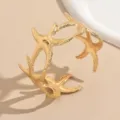 Dettaglio del bracciale da braccio a stella marina dorata, primo piano di gioielli creativi. - Oro