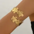 Bracciale da braccio aperto in metallo dorato con fiori multipli, primo piano dettagliato donna - Oro