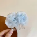 Nahaufnahme des eleganten hellblauen transparenten Stoff Blumen Haarkamm Detail Foto. - Blau