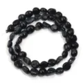 Primer plano de cuentas de piedra preciosa de ágata negra ovalada irregular para bricolaje. - Aprox. 45 Piezas/Paquete / Ojo de Tigre Azul