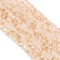 Primo piano dettagliato di perle di cristallo sfaccettato champagne per gioielli fai da te. - 100 Pezzi (4x3mm) / Giada Bianca Mezza Ambra