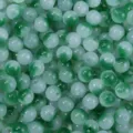 Nahaufnahme von grün-weißen Farbverlauf-Glasperlen für DIY-Schmuck und Bastelarbeiten. - Dunkelgrün