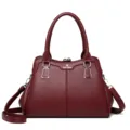 Burgundy faux leather top handle handbag featuring kiss-lock closure and shoulder strap. - Burgundy