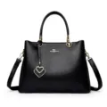 Elegant black leather handbag for women with shoulder strap and stylish heart pendant. - Black