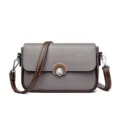 Stylish women's gray leather crossbody shoulder bag with brown strap and metal lock closure. - Gray
