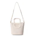 Detailansicht der cremefarbenen Leder-Eimer Tasche mit einzigartigen Griffen und Gurt. - Weiß