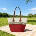 Detailansicht der Strohtasche im Boho-Stil mit rot-weißem Muster und braunen Ledergriffen. - Einzelne Tasche / Goldfaden Muster Rand / Rot