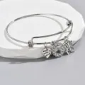 Detail view of silver adjustable wire bracelet with rhinestone letter G, heart and butterfly charms. - Style G