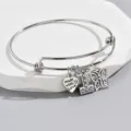 Close-up of silver wire bangle bracelet featuring rhinestone letter I, heart and butterfly charms. - Style I