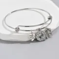 Adjustable silver wire bangle bracelet with heart, rhinestone letter Q, and butterfly charms. - Pattern Q