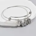 Detail shot of adjustable silver letter W and butterfly charm bracelet with rhinestones. - Pattern W