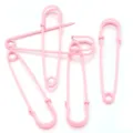 Detailed view of pink decorative safety pins, perfect for DIY crafts and clothing accessories. - Pink